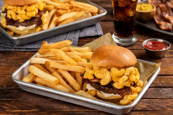 burger topped with mac and cheese and French fries on the side