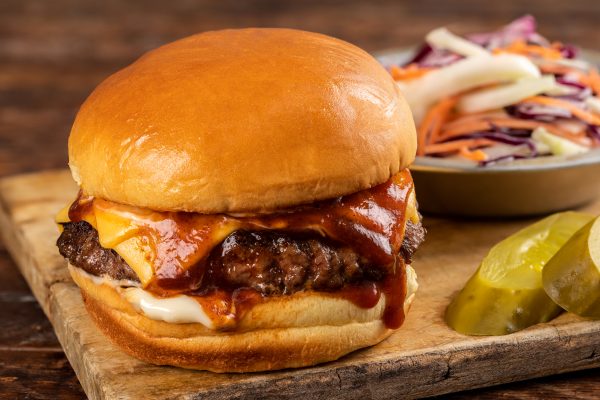 Burger with bbq sauce, cheddar cheese with a rounded bun top