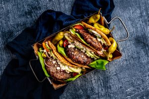 Tray of Burgers in a Pita with bright veggies. mediterranean burger recipe