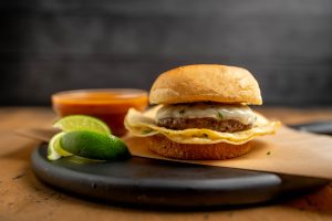 Birria Inspired Burger is a Burger with a Tortilla and dipping sauce