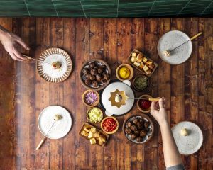 Overhead shot of a fondue layout with meatballs, cheese and other dishes.