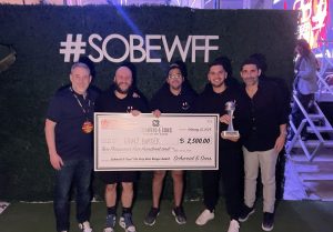 Cowy Burger holding a check as winners of the 2024 South Beach Wine & Food Festival Burger Bash event alongside Brad and Jamie Schweid