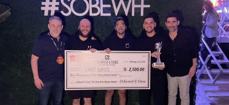 Cowy Burger holding a check as winners of the SOBEWFF Burger Bash event alongside Brad and Jamie Schweid