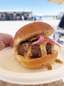 Slider Burger with a orange sauce drizzle and red onions