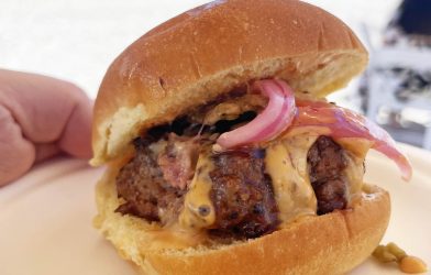 Slider Burger with a orange sauce drizzle and red onions
