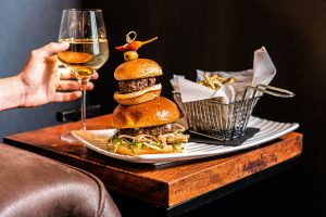 Juicy burger topped with cheese, onions, and lettuce with a side of fries.