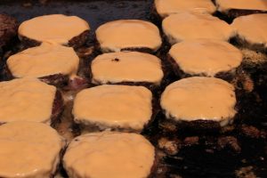 how to cook the perfect burger? you need the right surface and the right ingredients! Picture of burgers on a griddle with melted cheese