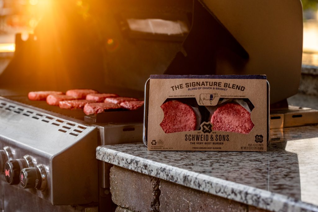schweid and sons signature blend burgers cooking on an open grill