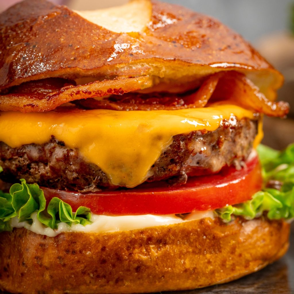 Classic cheeseburger using Schweid & Sons burgers topped with bacon, lettuce, cheese, tomato, and mayonnaise 