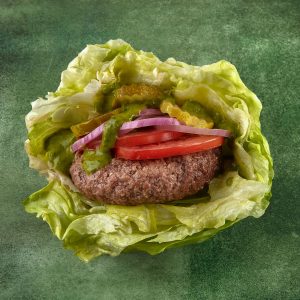 schweid and sons burger with a lettuce wrap topped with pickles, tomatoes, and red onions