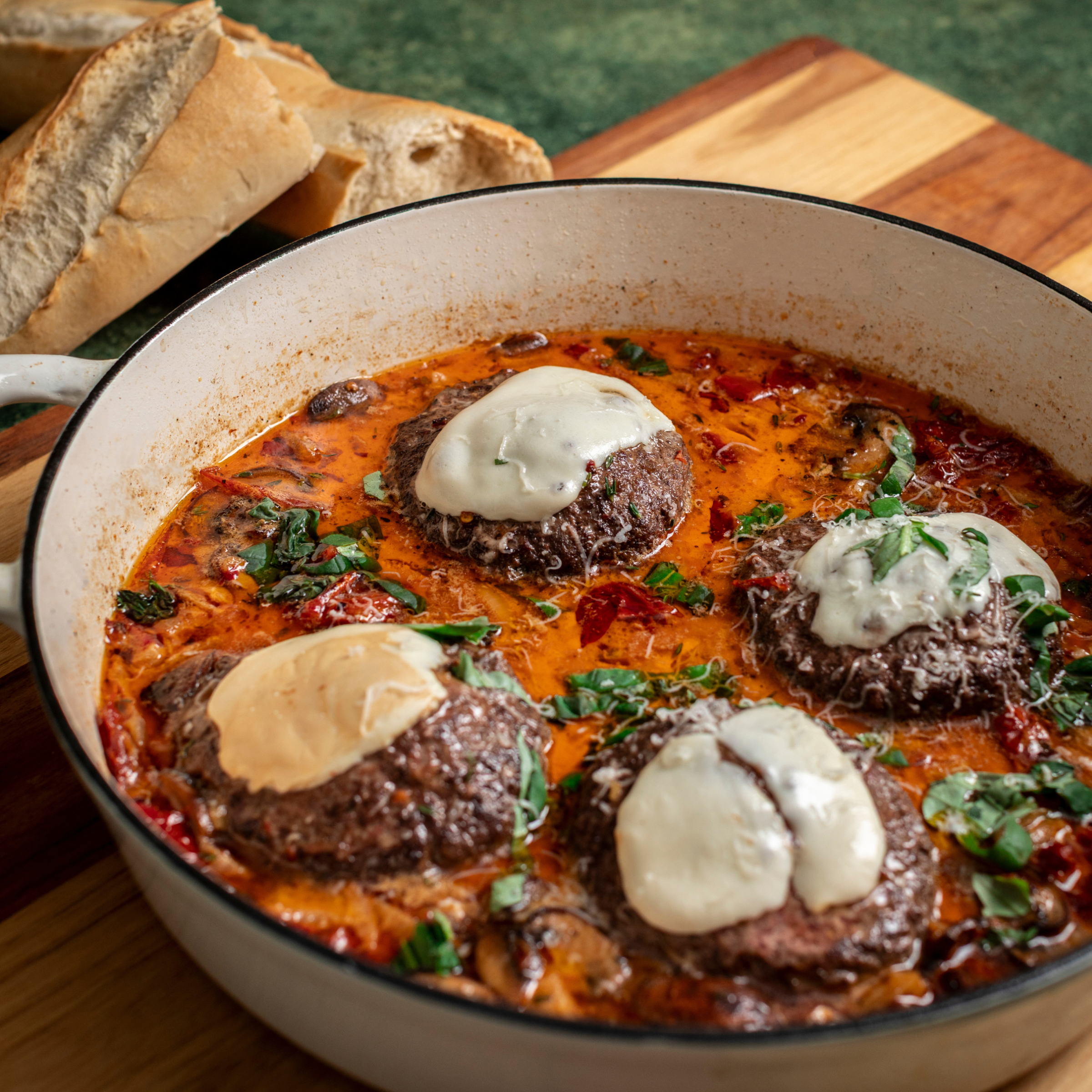Marry Me burger topped with melted mozzarella served in a tomato and broth sauce