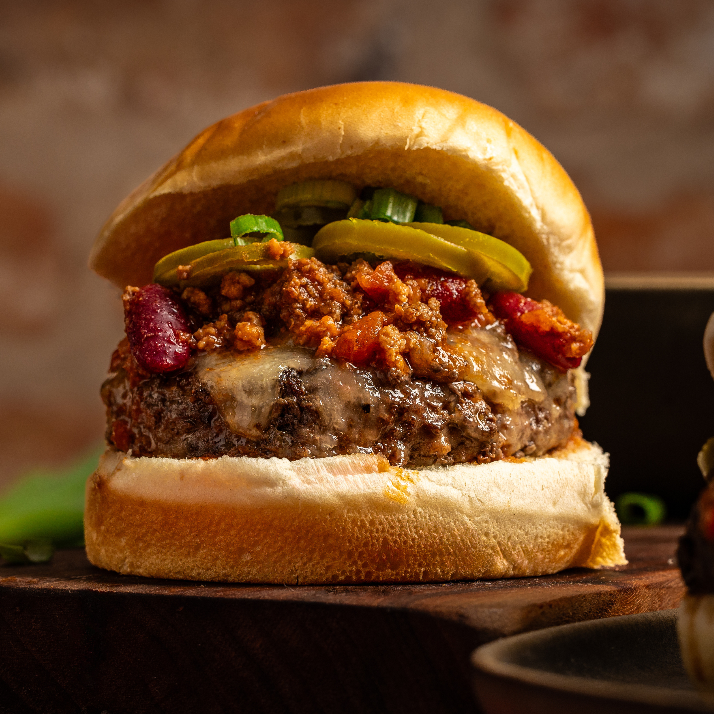 schweid and sons chili cheeseburger topped with chili and pickled jalapenos