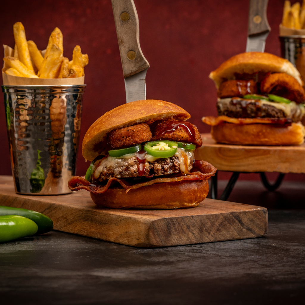 schweid and sons rodeo burger topped with bacon, cheese, onion rings, jalapenos, and barbecue sauce