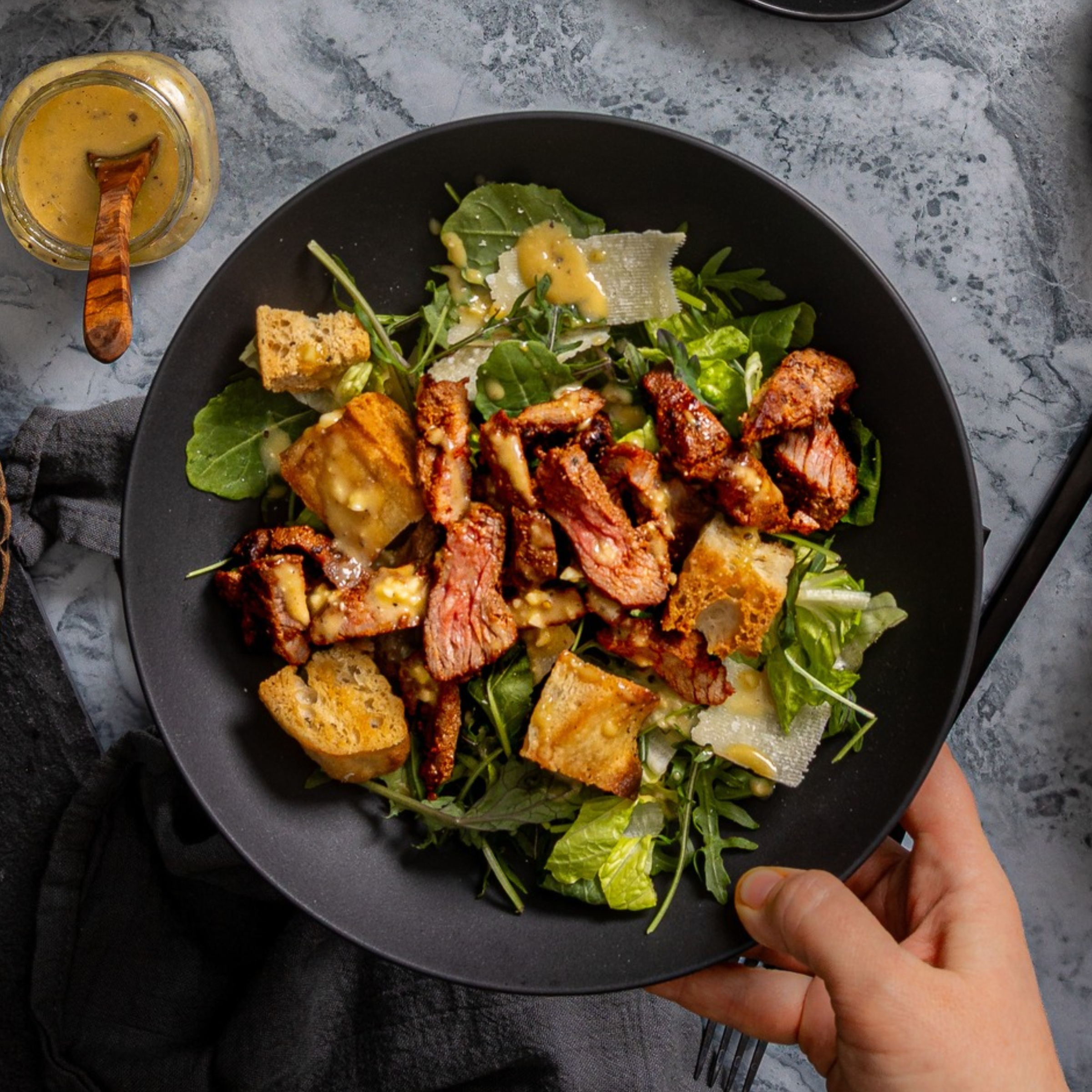 steak caesar salad made with romaine lettuce, focaccia croutons, and schweid and sons the cajun style tri-tip blend steak tips