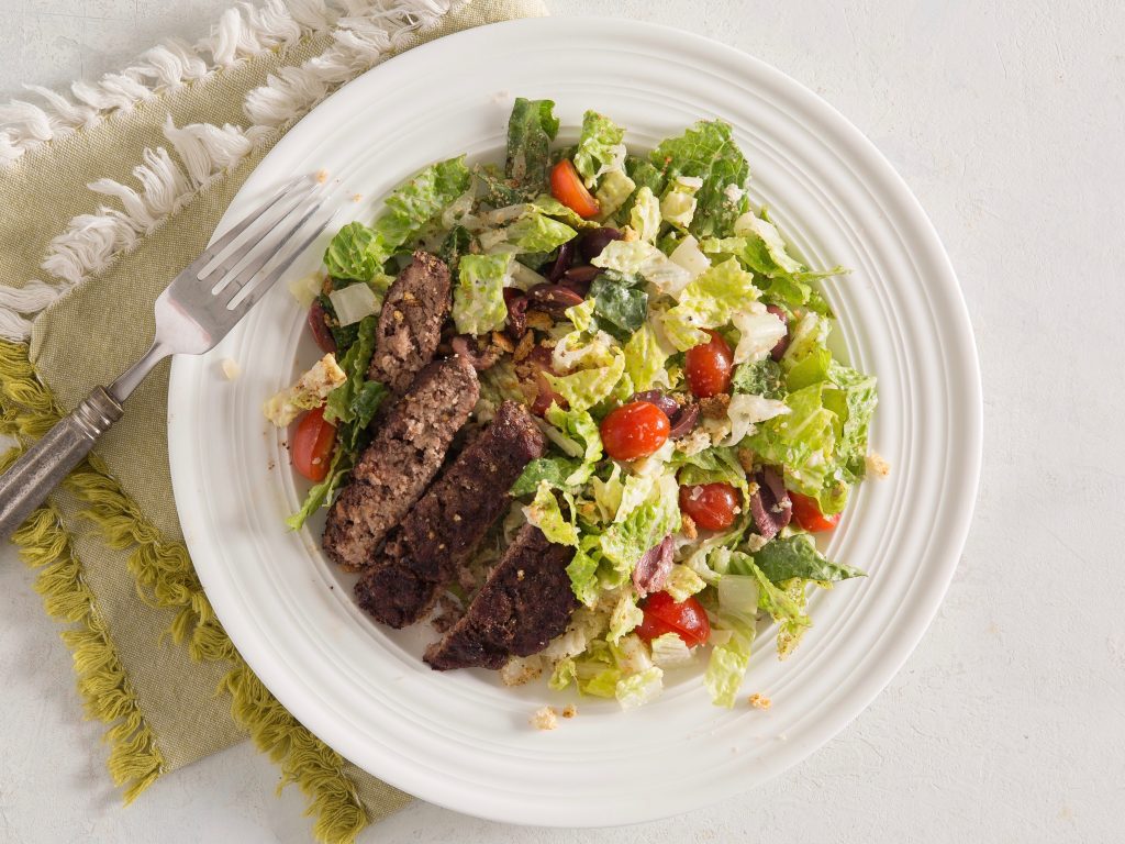 Schweid and sons burger with a Caesar salad and tomatoes